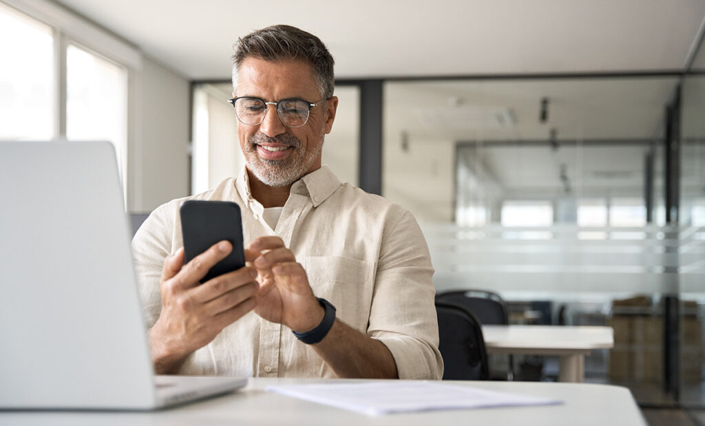 a person using a phone smiles after leaning how financial software streamlines patient billing