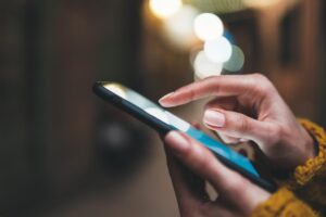 a person uses their phone to access the features of telehealth