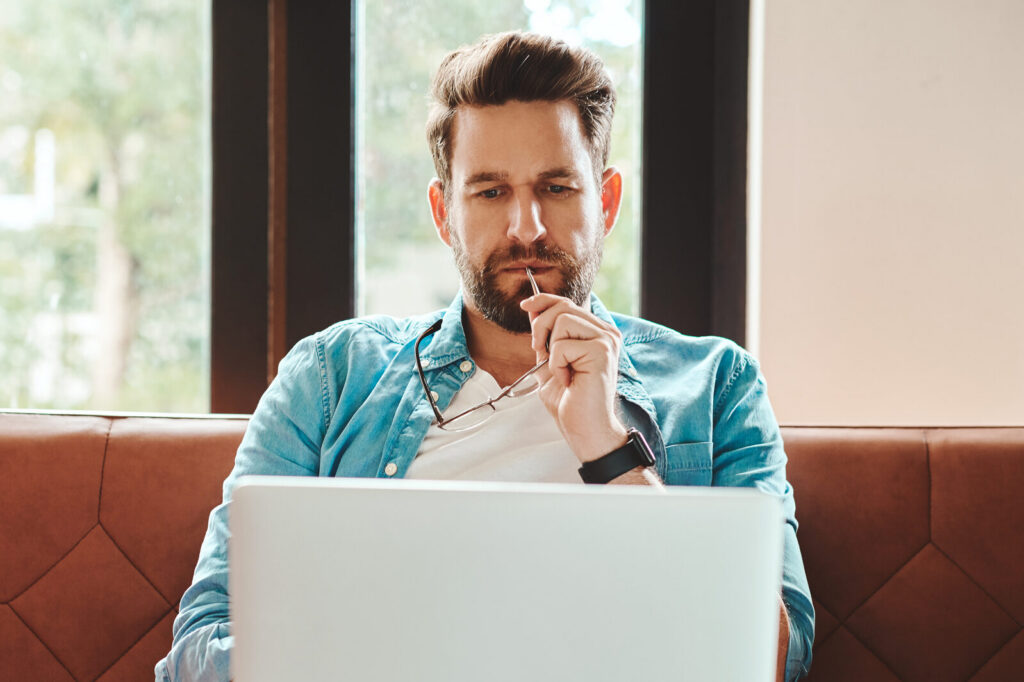 Cropped shot of a handsome young man using a laptop while chilling on the sofa at home
