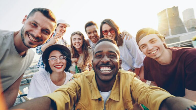 A group of young adults smiling together on a rooftop.