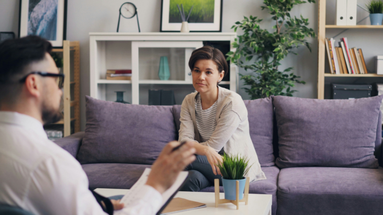 A behavioral health clinician meeting with a client in a counseling setting.