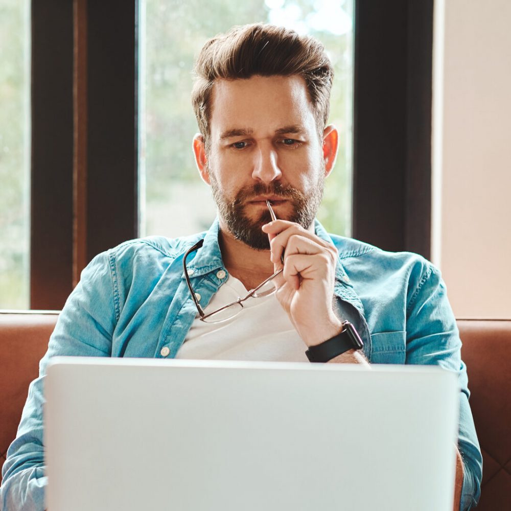 Cropped shot of a handsome young man using a laptop while chilling on the sofa at home