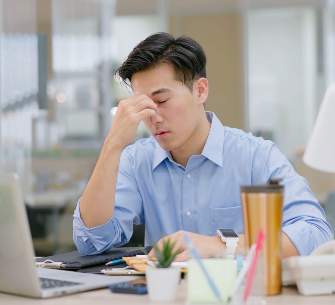 pain at work - stressed asian businessman suffer from eyes pain
