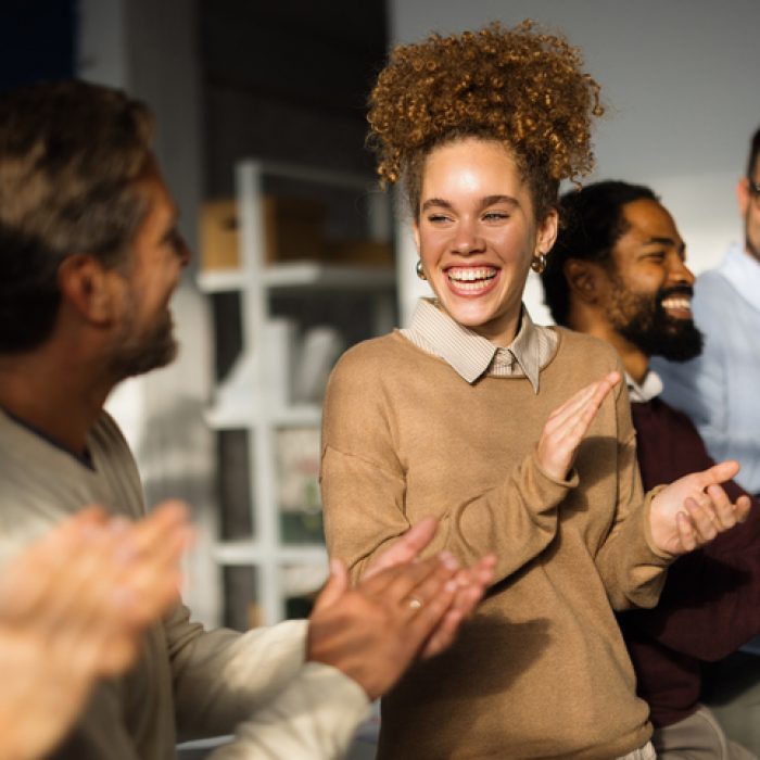 Group of happy multi-ethnic businesspeople clapping hands during a meeting in the office, celebrating success